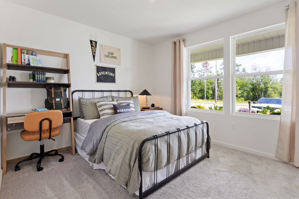 A bedroom with a bed and a chair.