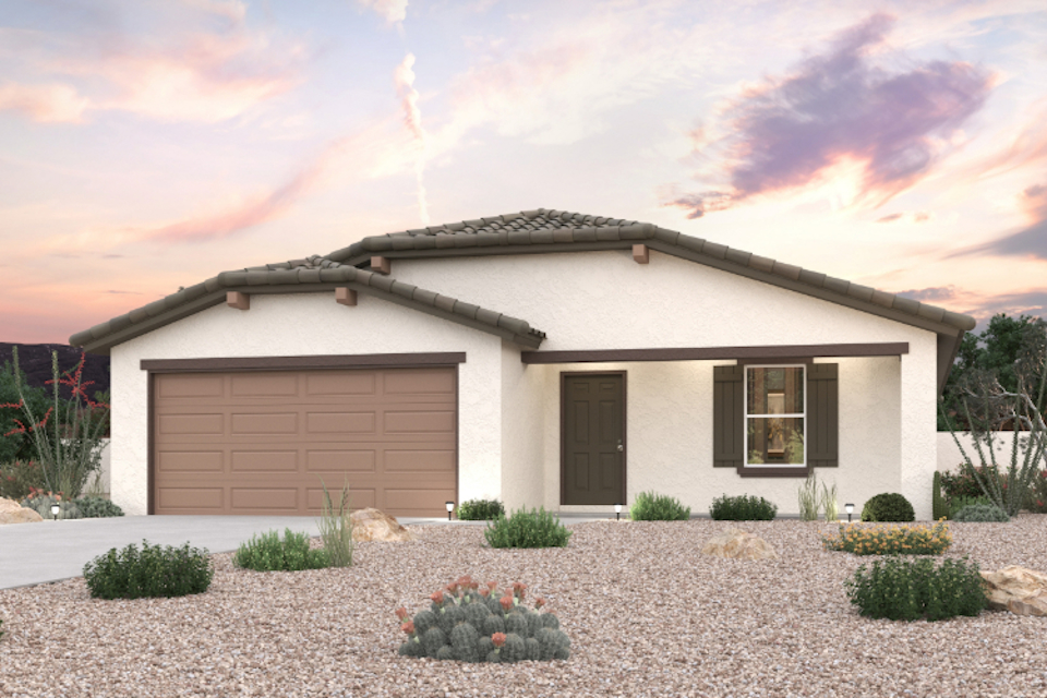 A house with a garage and bushes in front of it.