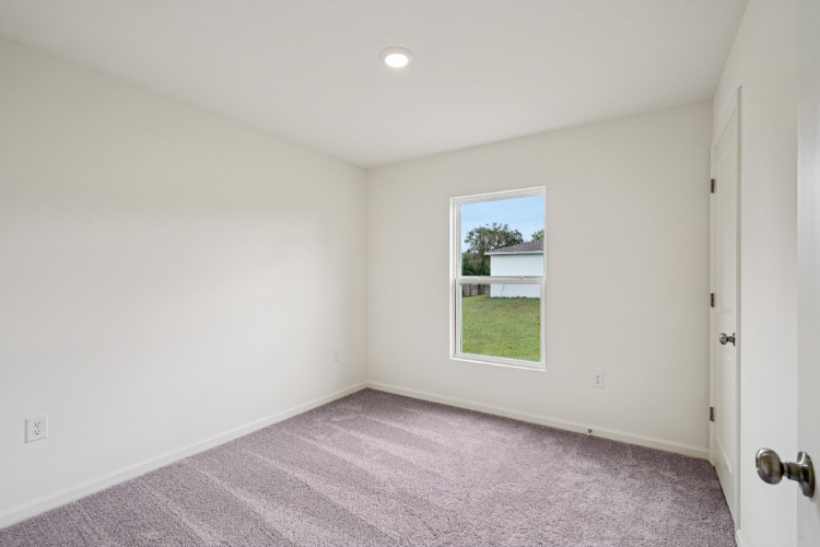 A room with a window and carpet.