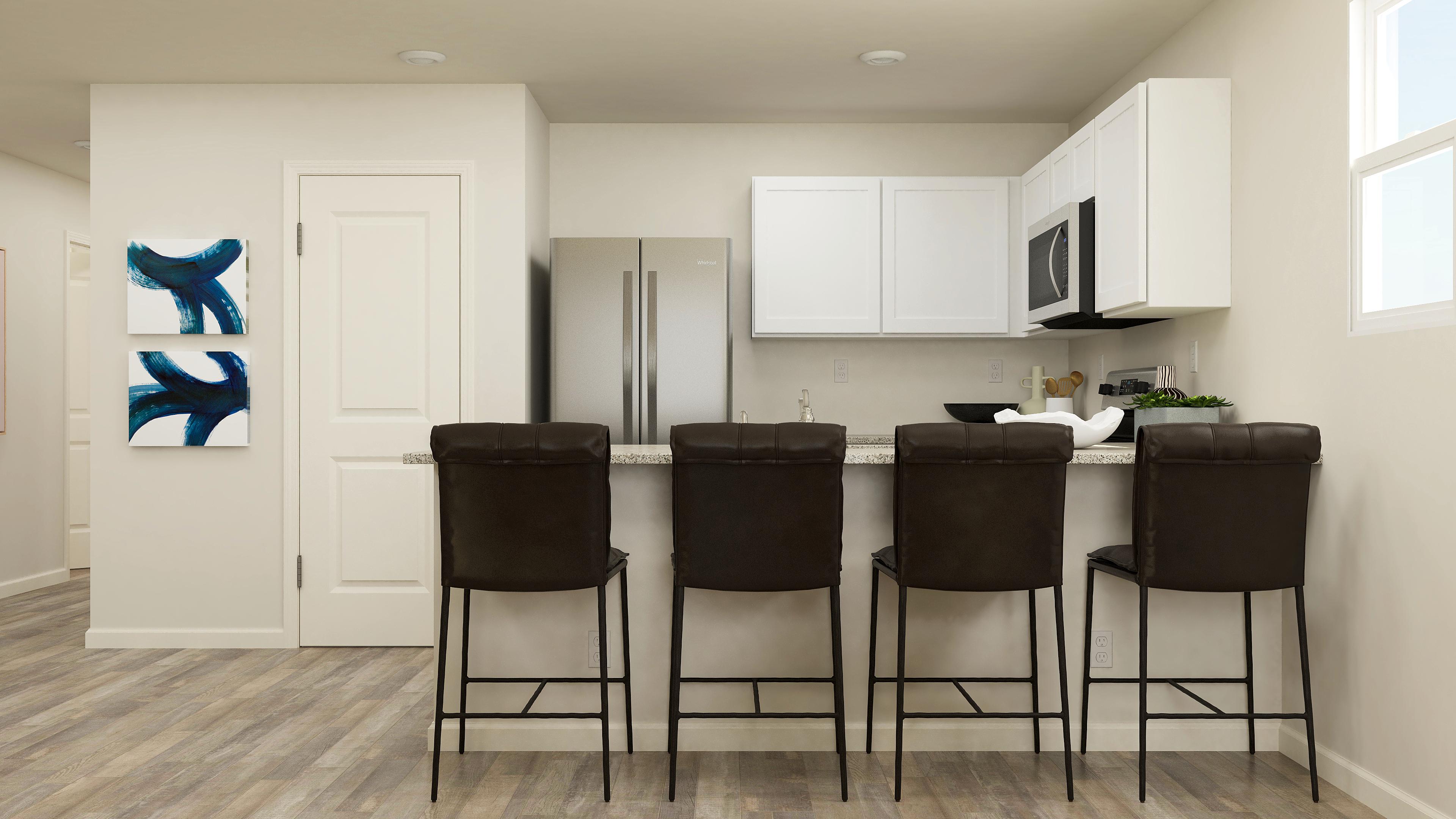 A kitchen with a table and chairs.
