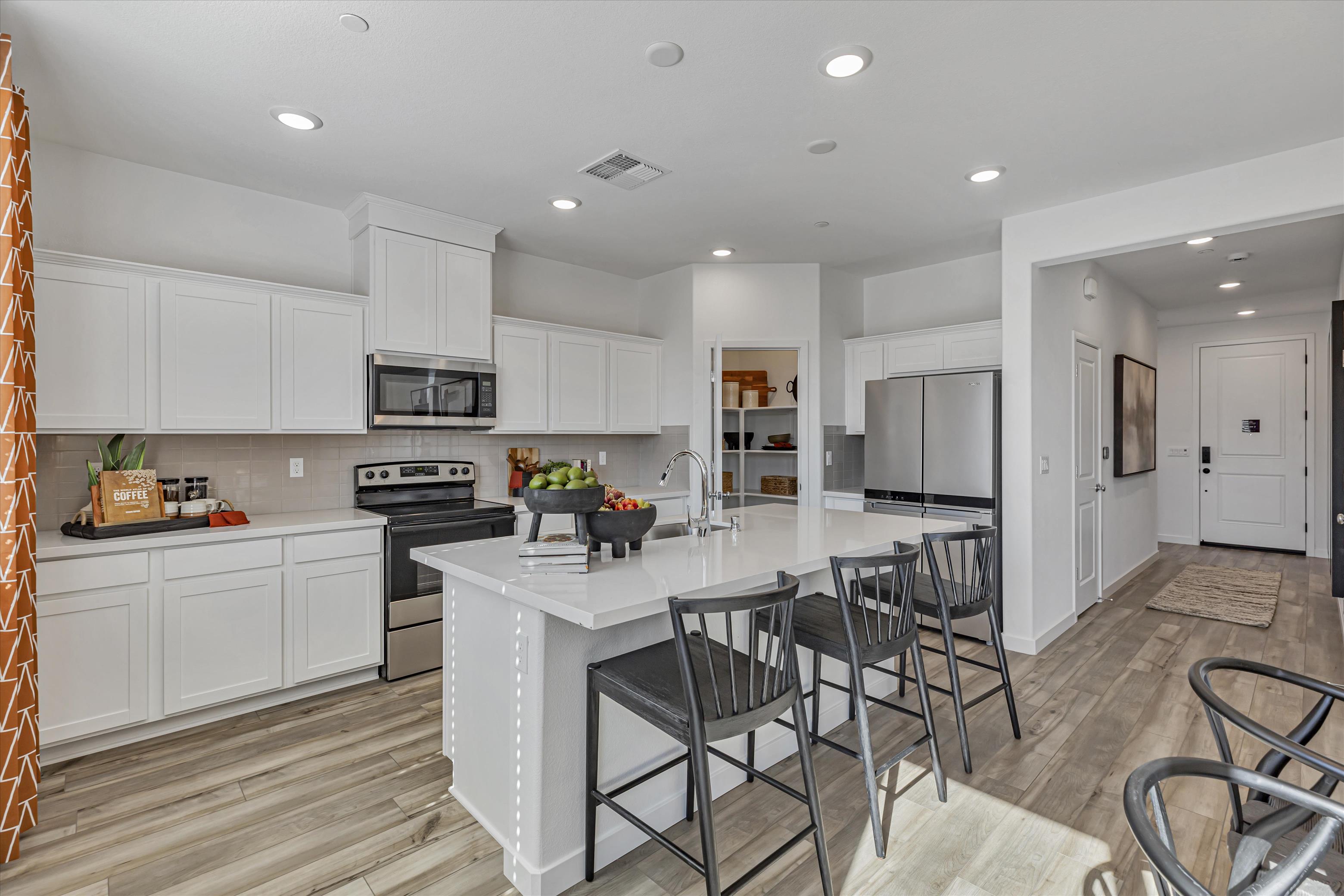 A kitchen with white cabinets.